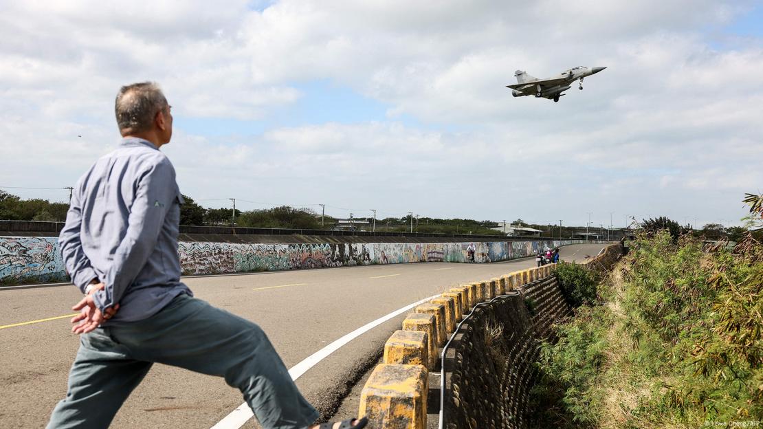 Homem observa caça da Força Aérea de Taiwan voando, em dezembro 