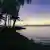Sunset framed by the ocean, beach and palm trees seen from Chuuk