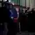 Calin Georgescu stands in front of the General Prosecutor's Office, surrounded by police, and waves to a crowd