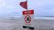 A sign warning people not to swim at a beach in Gold Coast A sign warning people not to swim at a beach in Gold Coast