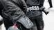 Zwei schwarz gekleidete Journalisten mit Tasche und Kamera, von hinten fotografiert. Auf einem Rücken steht die Aufschrift "Press". Zwei schwarz gekleidete Journalisten mit Tasche und Kamera, von hinten fotografiert. Auf einem Rücken steht die Aufschrift "Press".