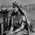 Black and white picture of a woman dressed in traditional Indian clothes.