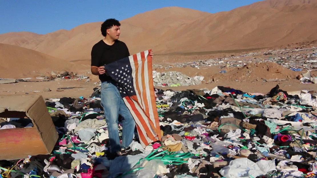 Un hombre sostiene una bandera de Estados Unidos recogida de entre los restos de ropa en una imagen reciente. Un hombre sostiene una bandera de Estados Unidos recogida de entre los restos de ropa en una imagen reciente.