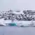 Colored houses in Greenland overlooking icy water.