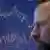A trader on the New York Stock Exchange watching a screen showing stocks