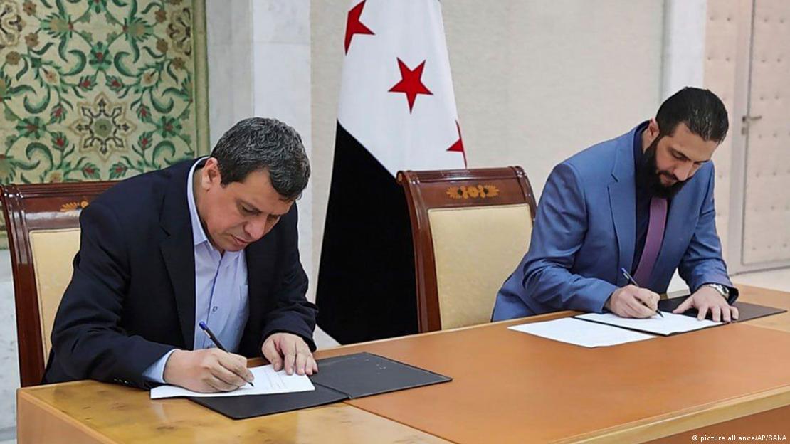 Ahmed Şara ve Mazlum Abdi önlerindeki belgeye imza atıyorlar