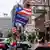 Los manifestantes enarbolan una bandera de Puerto Rico junto a una de la campaña de Donald Trump y otra de los Estados Unidos.