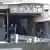 Firefighter, others walking into a damaged building, sign saying: 'Club Pulse'