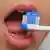 La boca de un niño con un cepillo de dientes con pasta dentífrica.