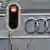 A traffic light set to red can be seen in front of the Audi rings at Audi headquarters