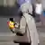 Black women with headscarf, mobile phone and bag of churros