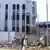 Sudanese men walk past a bullet-riddled building in Khartoum's twin-city Omdurman