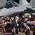 French President Emmanuel Macron stands amid French airforce personnel with a Dassault Rafale fighter jet behind him on March 18, 2025.