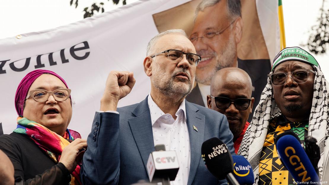 Der aus Washington ausgewiesene Botschafter Südafrikas, Ebrahim Rasool hebt, umringt von Unterstützenden, seine Hand zu einer Faust, während er von Medien am Cape Town International Airport in Südafrika interviewt wird 