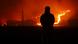 A resident looks on as a wildfire devastates the area in Andong, South Korea. He's seen from behind in the shadows, while the fire glows bright red and orange. A resident looks on as a wildfire devastates the area in Andong, South Korea. He's seen from behind in the shadows, while the fire glows bright red and orange.