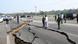 People inspect fissures in a motorway