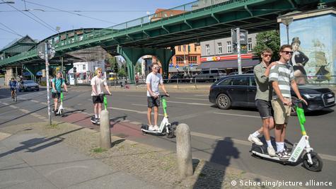 Pessoas pilotam scooters em Berlim