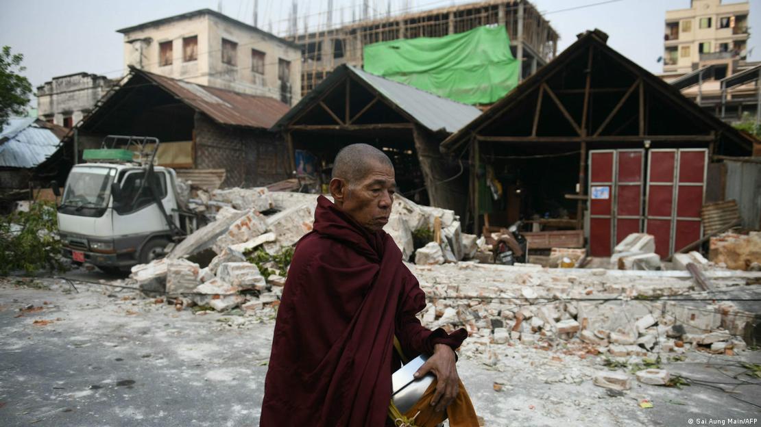 Monge caminha por rua de Mandalay com casas parcialmente destruídas por terremeto em Mianmar Monge caminha por rua de Mandalay com casas parcialmente destruídas por terremeto em Mianmar