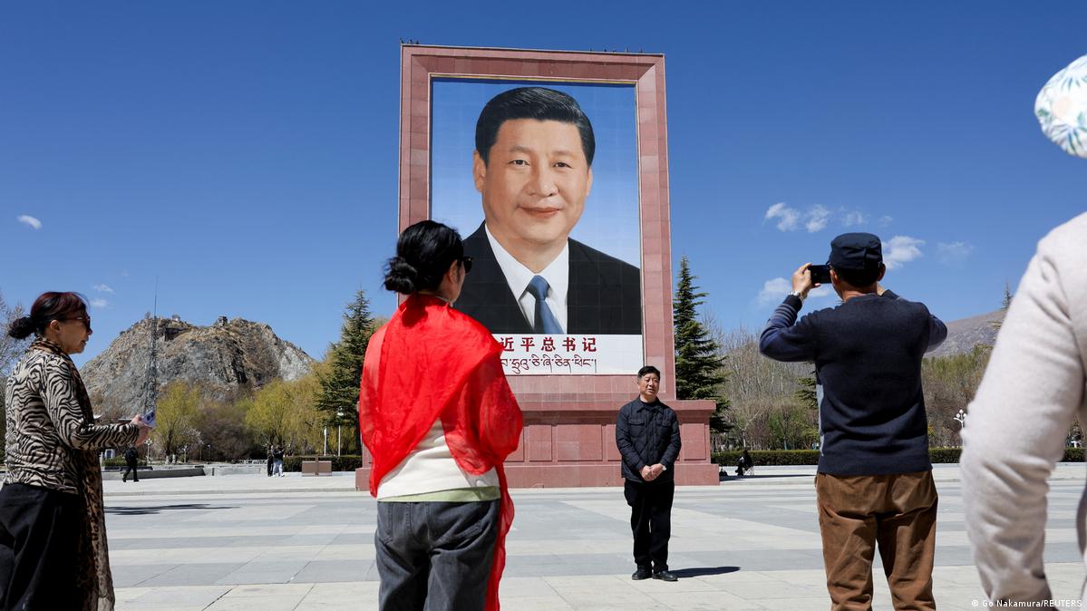 游客在位于拉萨布达拉宫广场的巨幅习近平画像前拍照