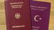 Zwei Pässe liegen nebeneinander - der deutsche (l.) und der türkische. Auf dem Deckel des deutschen Dokuments steht jeweils in goldener Schrift und in Großbuchstaben "Europäische Union" (oben), "Bundesrepublik Deutschland" (darunter) und "Reisepass" (unten). In der Mitte ist der Bundesadler mit gespreizten Flügeln aufgedruckt. Der türkische Pass ist lila. Oben steht in türkischer und englischer Sprache "Türkische Republik", unten in denselben Sprachen "Reisepass" und in der Mitte sind - wie auf der Landesfahne - eine Mondsichel und ein Stern zu sehen. 