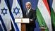 El primer ministro israelí habla desde el atril con dos banderas de Israel y dos banderas de Hungría detrás. El primer ministro israelí habla desde el atril con dos banderas de Israel y dos banderas de Hungría detrás.