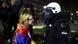 A woman with a Serbian flag draped over her shoulders stands face to face with a police officer in full riot gear A woman with a Serbian flag draped over her shoulders stands face to face with a police officer in full riot gear