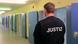 A corrections officer wearing a vest with the word 'Justiz' on it, is seen from behind as he looks down a long, low hallway lined with blue steel doors and illuminated by flourescent lights at Burg Prison in the eastern German state of Saxony-Anhalt A corrections officer wearing a vest with the word 'Justiz' on it, is seen from behind as he looks down a long, low hallway lined with blue steel doors and illuminated by flourescent lights at Burg Prison in the eastern German state of Saxony-Anhalt