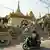 People ride a scooter past the rubble of damaged Buddhist pagoda in Mandalay