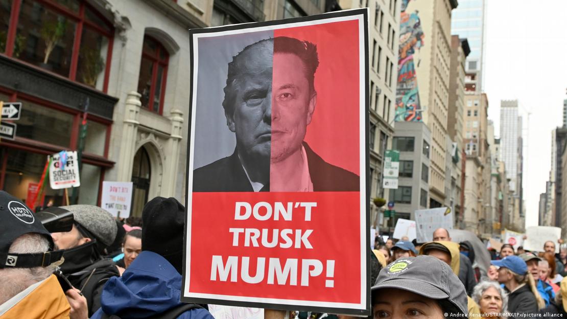 Demonstrierende in New York mit Plakaten gegen die Politik von Donald Trump und Elon Musk