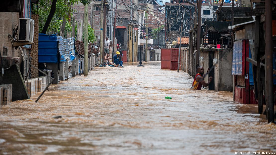 Un residente camina a través de las turbias aguas de las inundaciones luego de las fuertes lluvias en el distrito de Ndjili, de Kinsasa, el 6 de abril de 2025.
