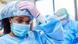 A woman wears personal protective medical clothing, such as latex gloves, a hair net and face mask. A woman wears personal protective medical clothing, such as latex gloves, a hair net and face mask.
