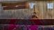 man and woman, partially obscured by hanging threads, weave a complex traditional rug man and woman, partially obscured by hanging threads, weave a complex traditional rug
