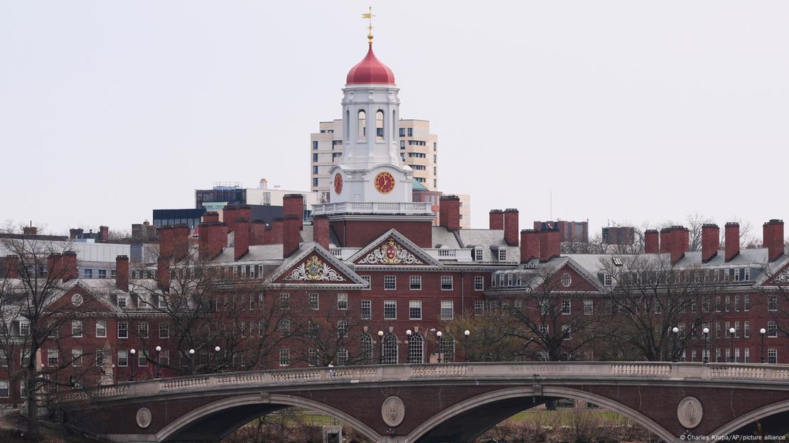 View of Harvard University - redbrick buildings like a group of large houses with a bell tower in the middle - across the bridge over the Charles River View of Harvard University - redbrick buildings like a group of large houses with a bell tower in the middle - across the bridge over the Charles River