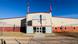 View of the detention facility in Texas, barbed-wire topped fences in front of a building with protruding entrance hall and warehouse-like wings. View of the detention facility in Texas, barbed-wire topped fences in front of a building with protruding entrance hall and warehouse-like wings.