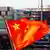 A Chinese flag flies from a ship docked at the Port of Oakland