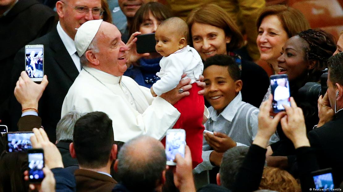 Francisco toma a un niño en brazos durante una audiencia en el Vaticano, diciembre de 2016.