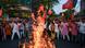 BJP protesters wave flags in front of flaming debris in Kolkata BJP protesters wave flags in front of flaming debris in Kolkata