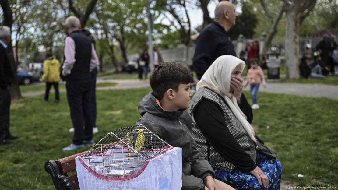23 Nisan'da Silivri'deki depremin ardından parka giden vatandaşlar. Küçük bir çocuk kafesteki kuşu ve annesiyle bankta oturuyor 
