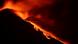 Lava encendida fluyendo pendiente abajo por la ladera del Etna.