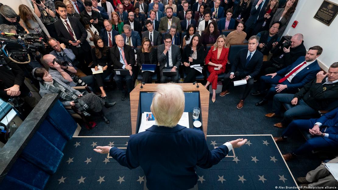 Trump, de costas, em coletiva de imprensa na Casa Branca