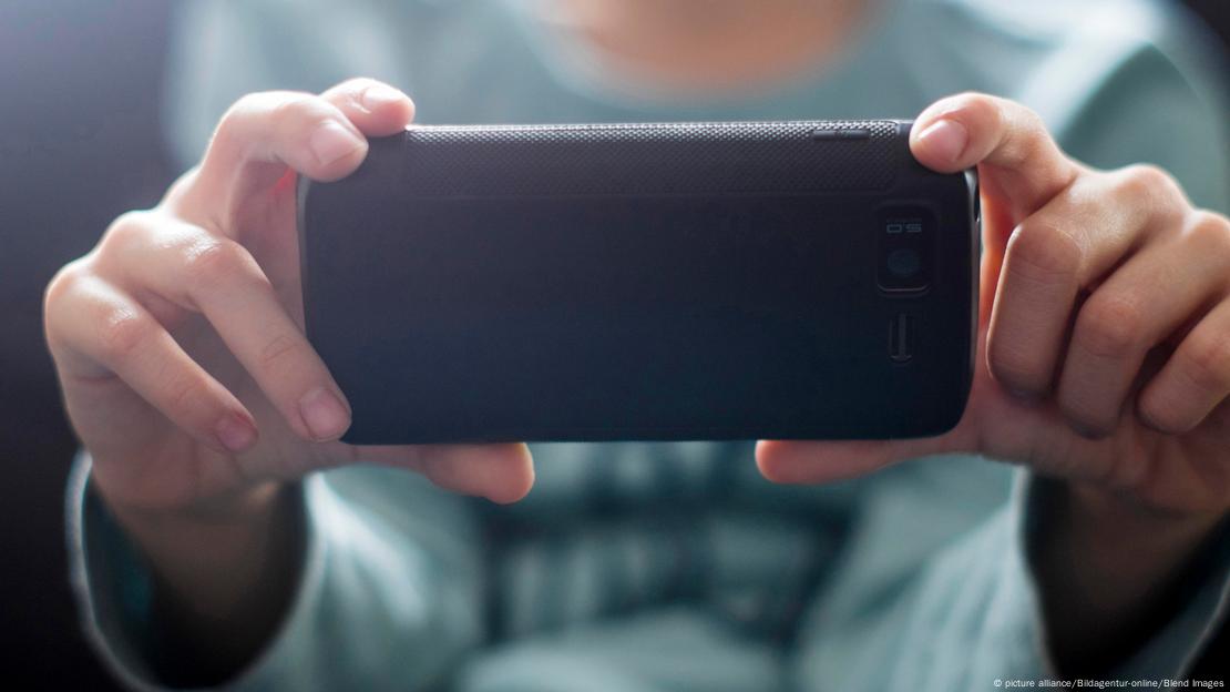 Close nas mãos de um jovem segurando um celular Close nas mãos de um jovem segurando um celular