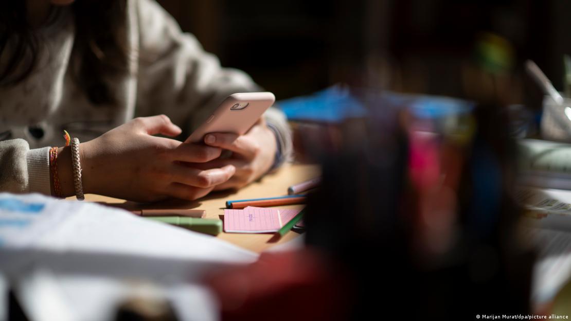 Akıllı telefon tutan eller ve bir çalışma masası