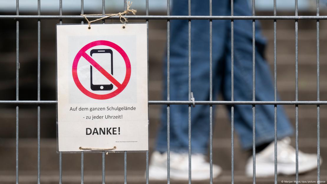 Un cartel en alemán anuncia que está prohibido usar celulares en la escuela. Un cartel en alemán anuncia que está prohibido usar celulares en la escuela.