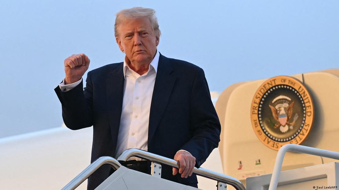 US-Präsident Donald Trump verlässt die Präsidentenmaschine Air Force One mit erhobener rechter Hand, zur Faust geballt 