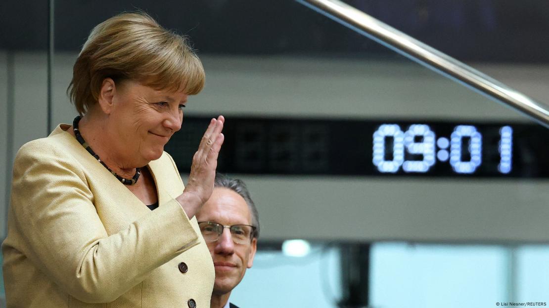 Ish-kancelarja Angela Merkel përshëndet të pranishmit në sallën plenare të Bundestagut në fillim të seancës për votimin për kancelarin e ri