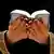 The hands of a woman holding the Quran