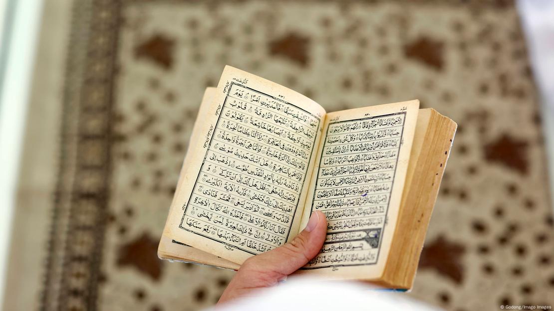 A male hand holding the Quran A male hand holding the Quran