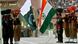 Indian, in khaki, and Pakistani soldier, in black, lower their respective national flags during a ceremony at the India-Pakistan joint border check post, Wagah, India
