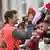 Thomas Müller gibt nach dem Training lächelnd Autogramme für zahlreiche Fans des FC Bayern
