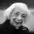 A black and white photo of a old woman with short,shoulder length white hair, smiling